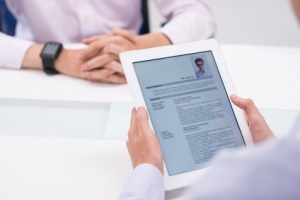 Close-up image of employer reading cv of job candidate